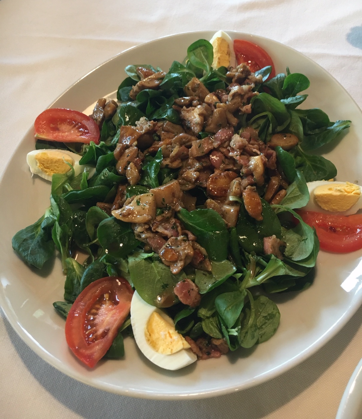 Nüsslisalat mit Steinpilzen, Speck, Ei und Tomate